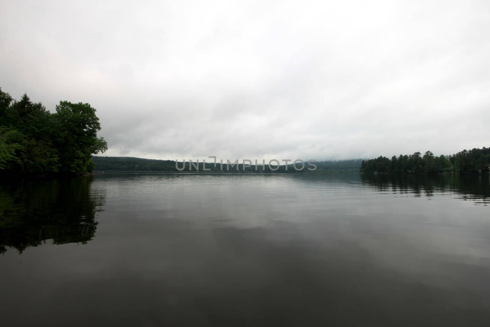 Calm lake Massawippi in the early morning with a bit of fog