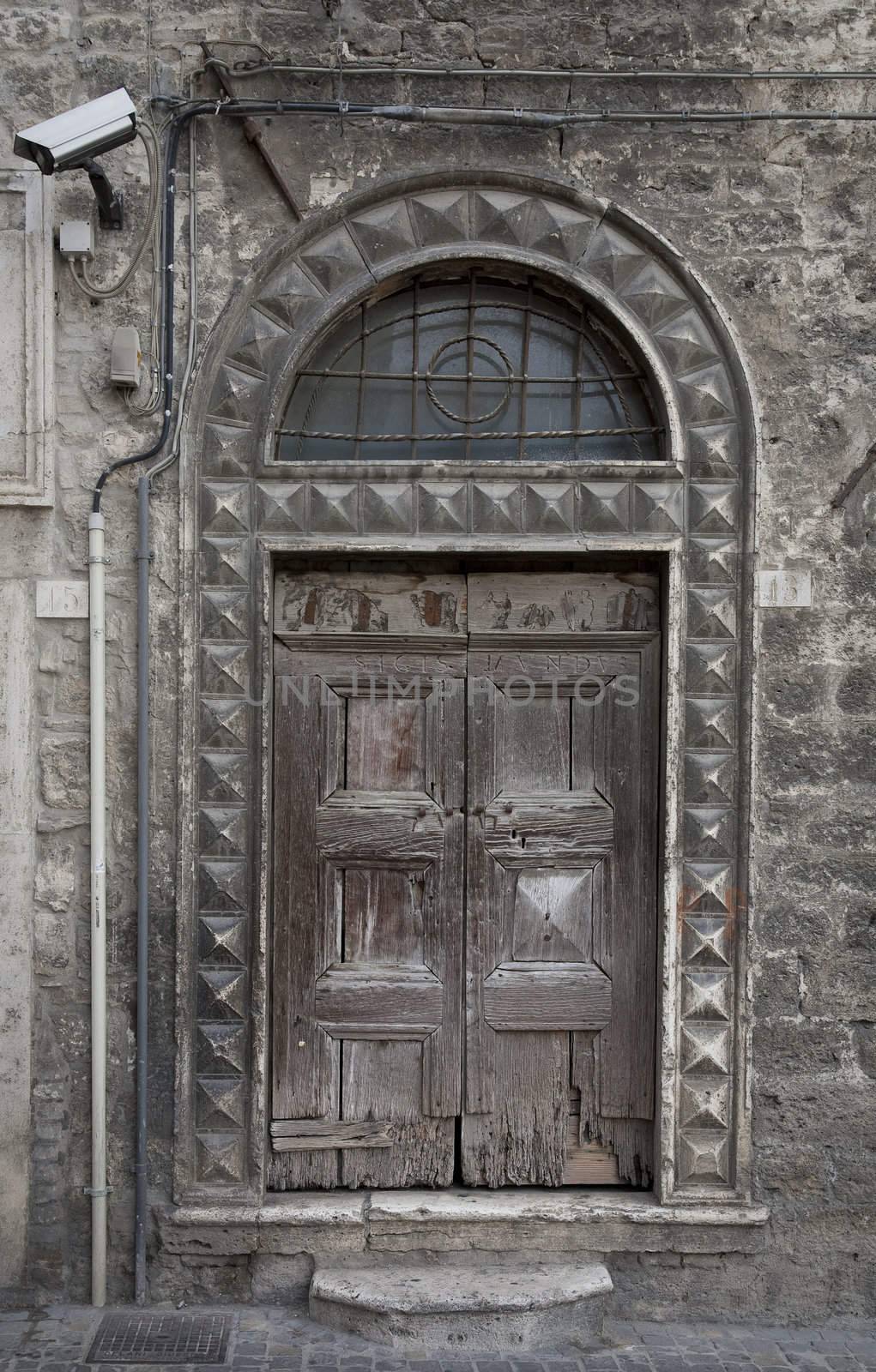 Beautiful old urban weathered entrance with surveillance camera Ascoli Piceno, Marche - Italy.