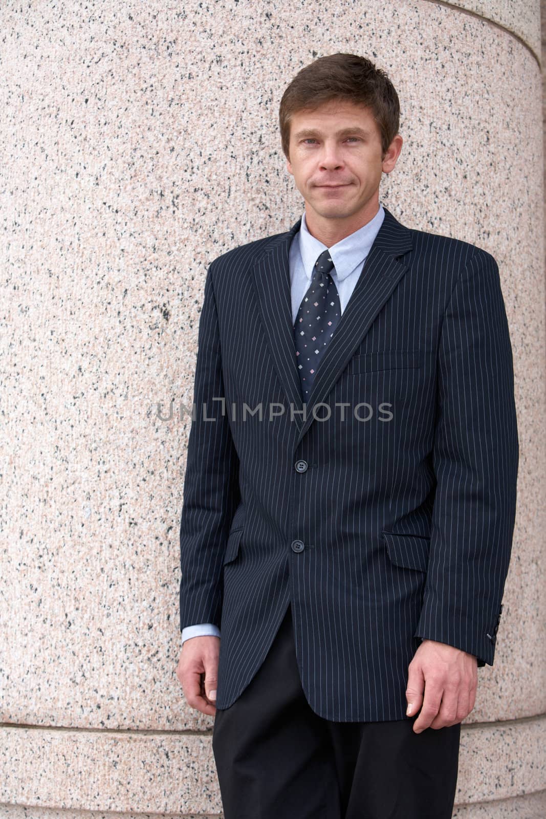 Man standing by pillar of building