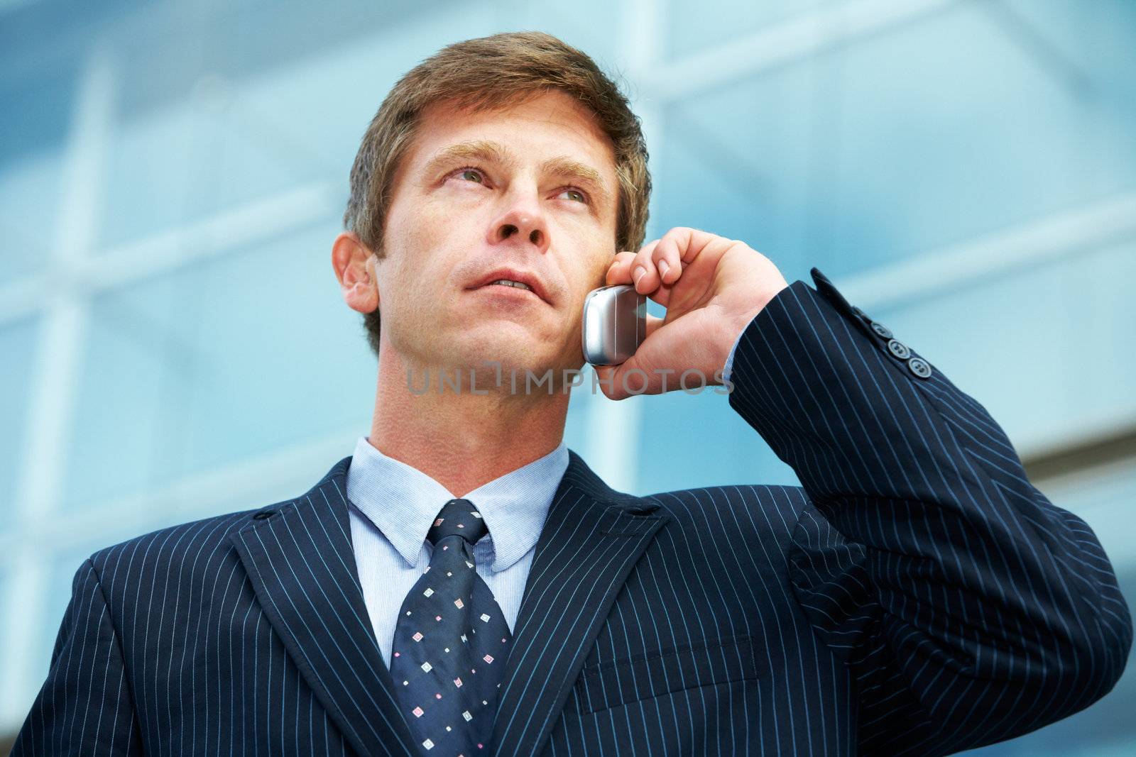 Man outside office building, using cell phone