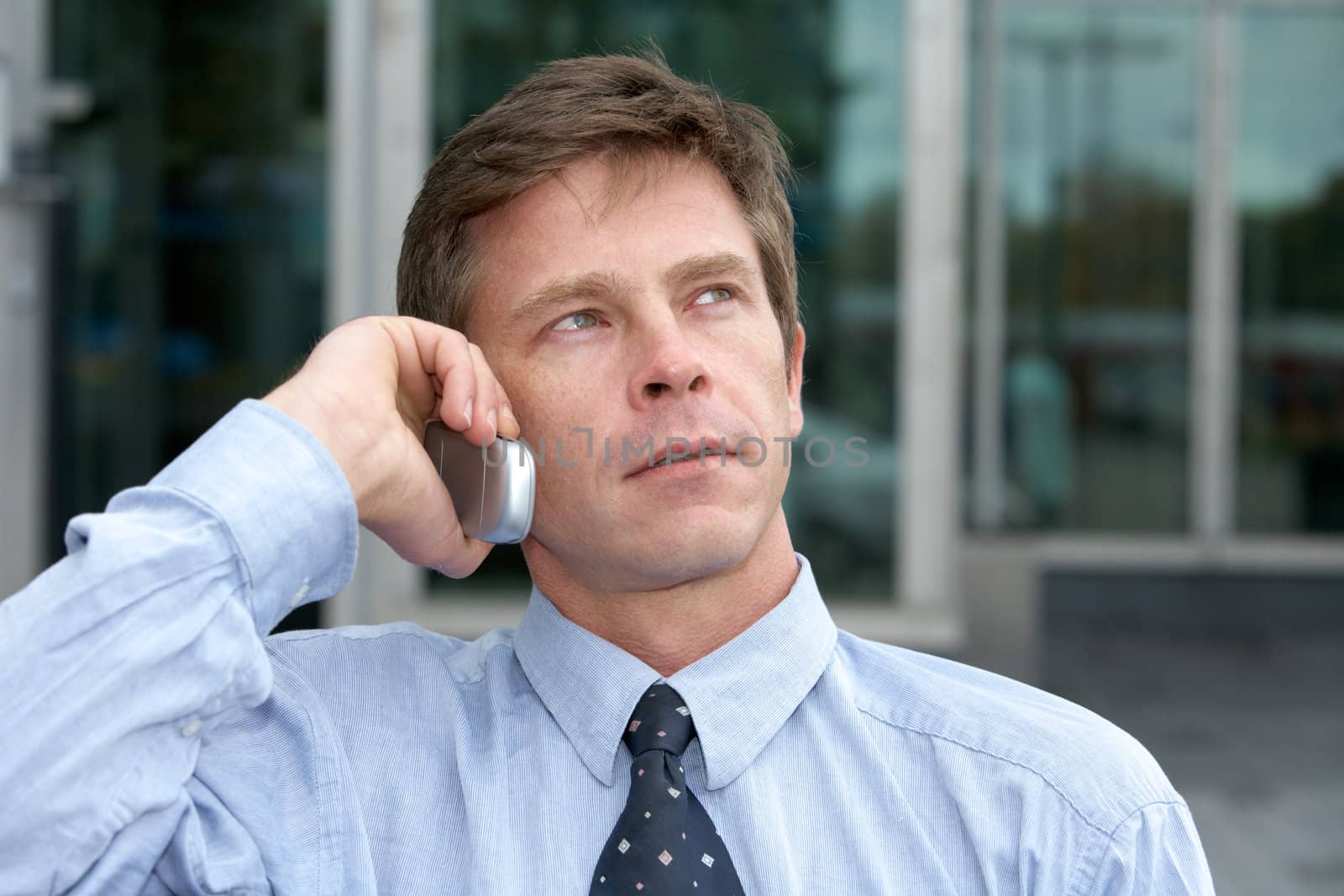 Man using cell phone outdoors, looking up