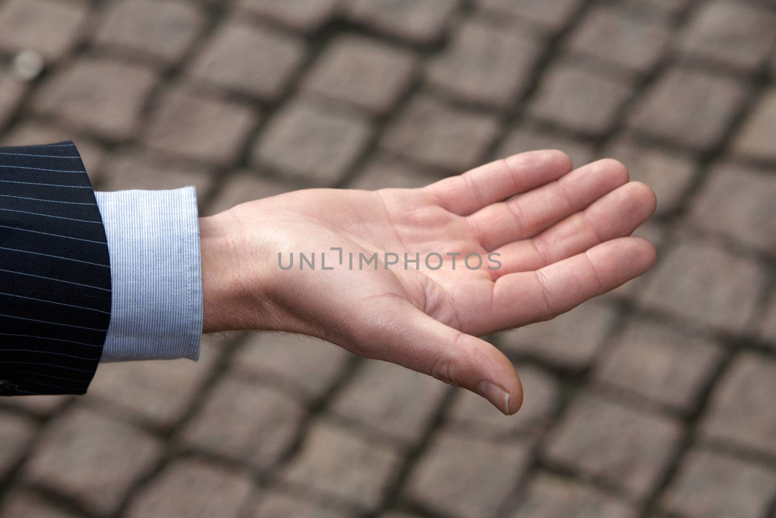 Hand of man against pavement, close-up