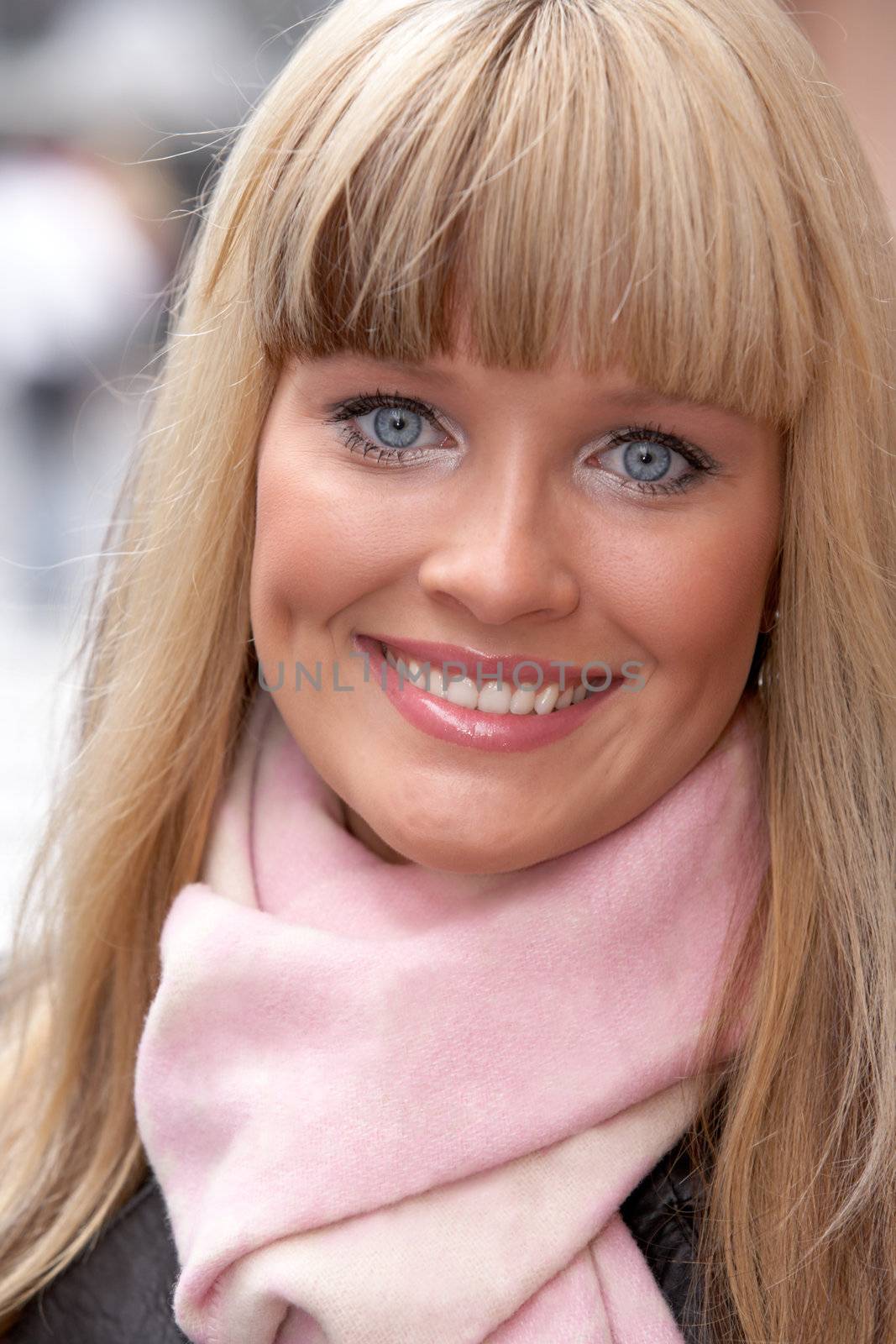 Young woman wearing scarf, looking at camera, smiling