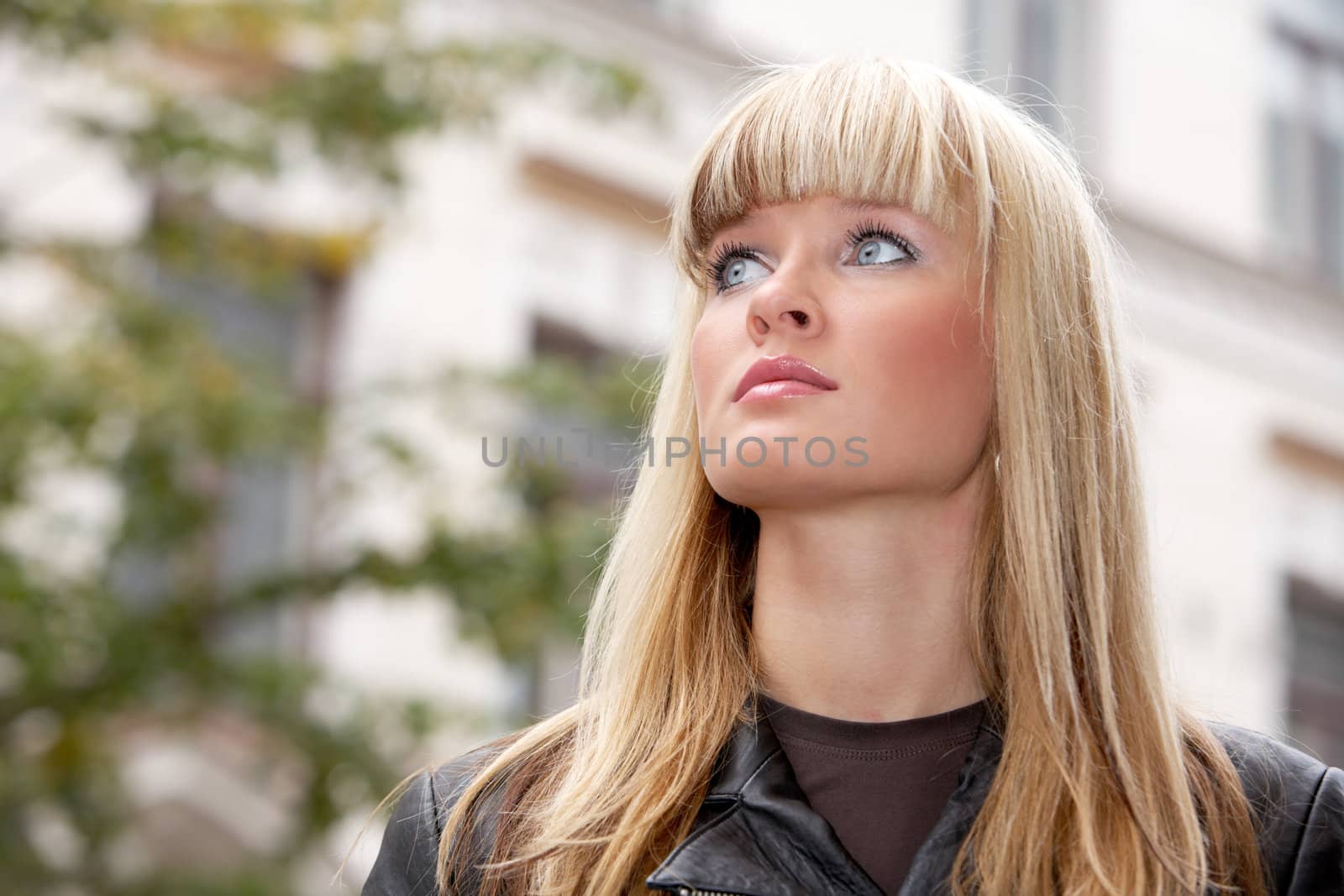 Portrait of young woman in city, looking away