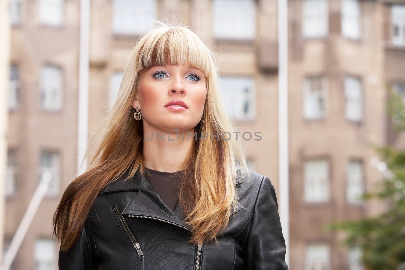 Portrait of young woman standing in city, looking away