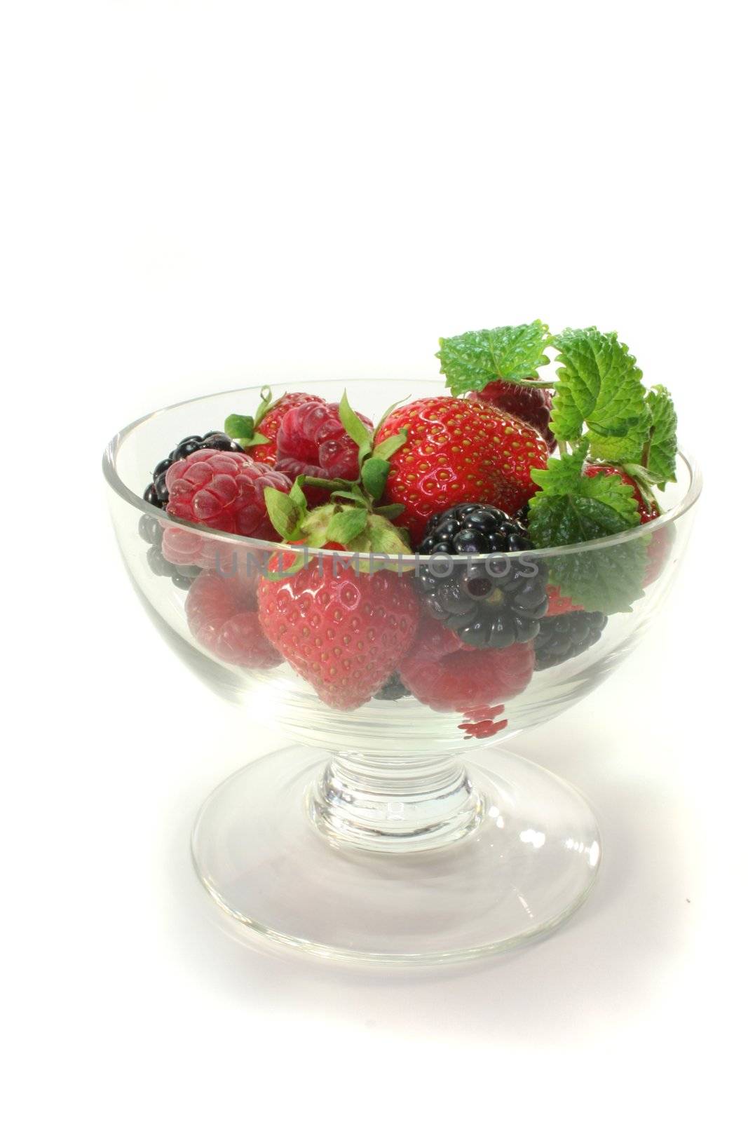 fresh berries in a small bowl with lemon balm