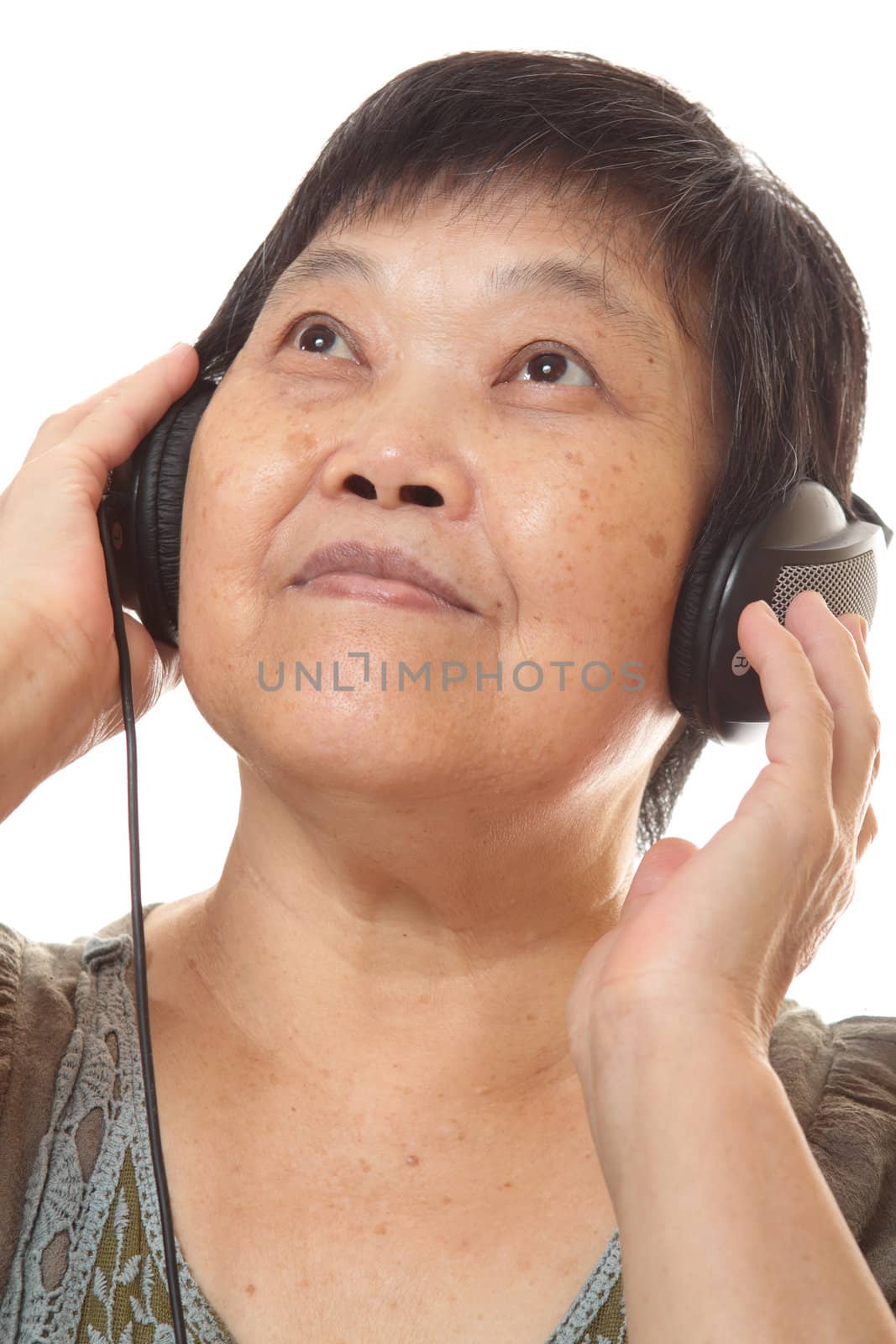 Senior woman listening to music with headphones  by cozyta