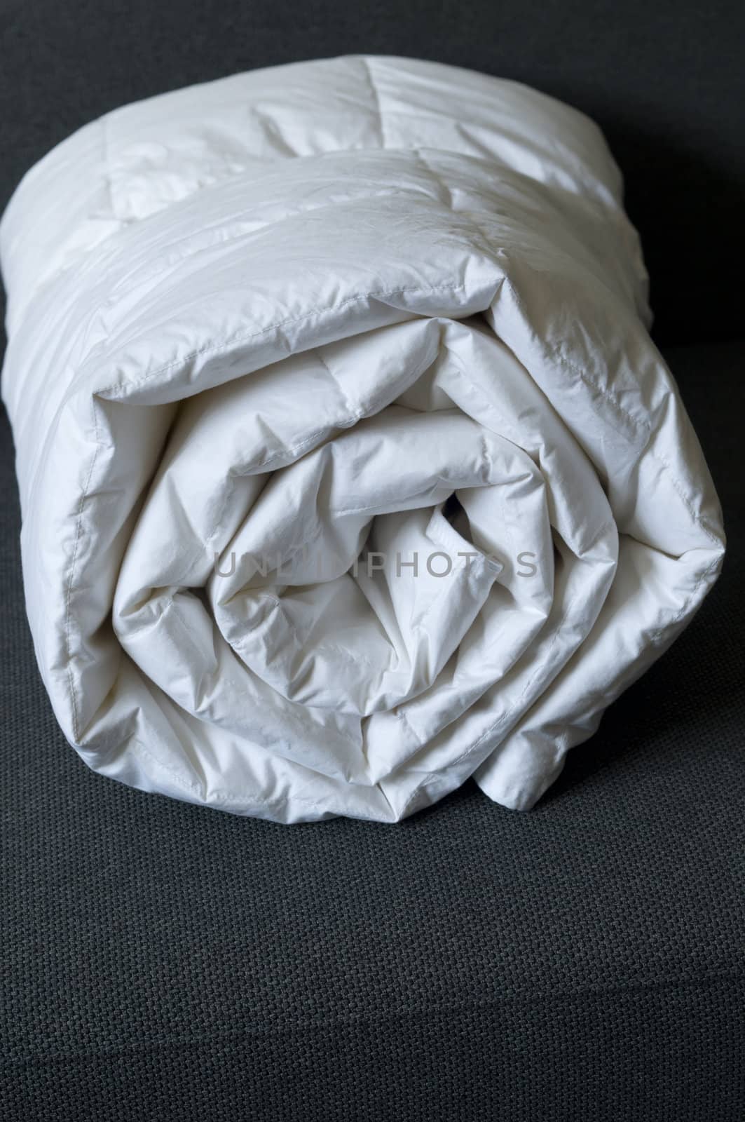 Detail of a rolled white down comforter