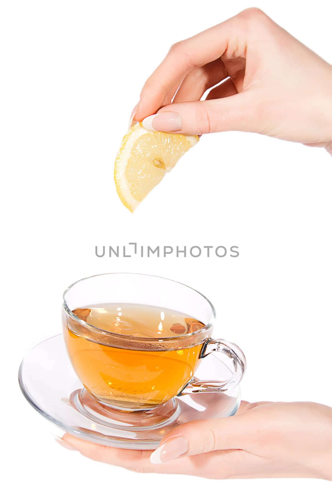 Woman hand adding lemon to tea over white