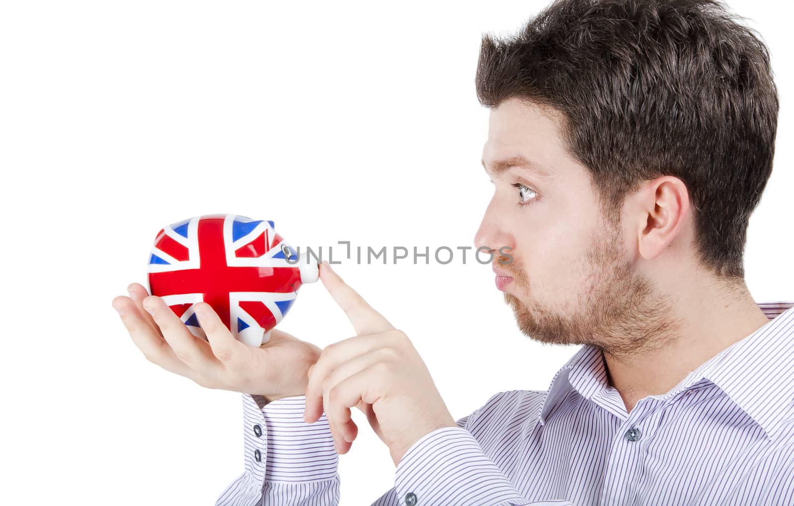 Isolated photograph of a blonde British man playing with a piggy bank with UK flag.