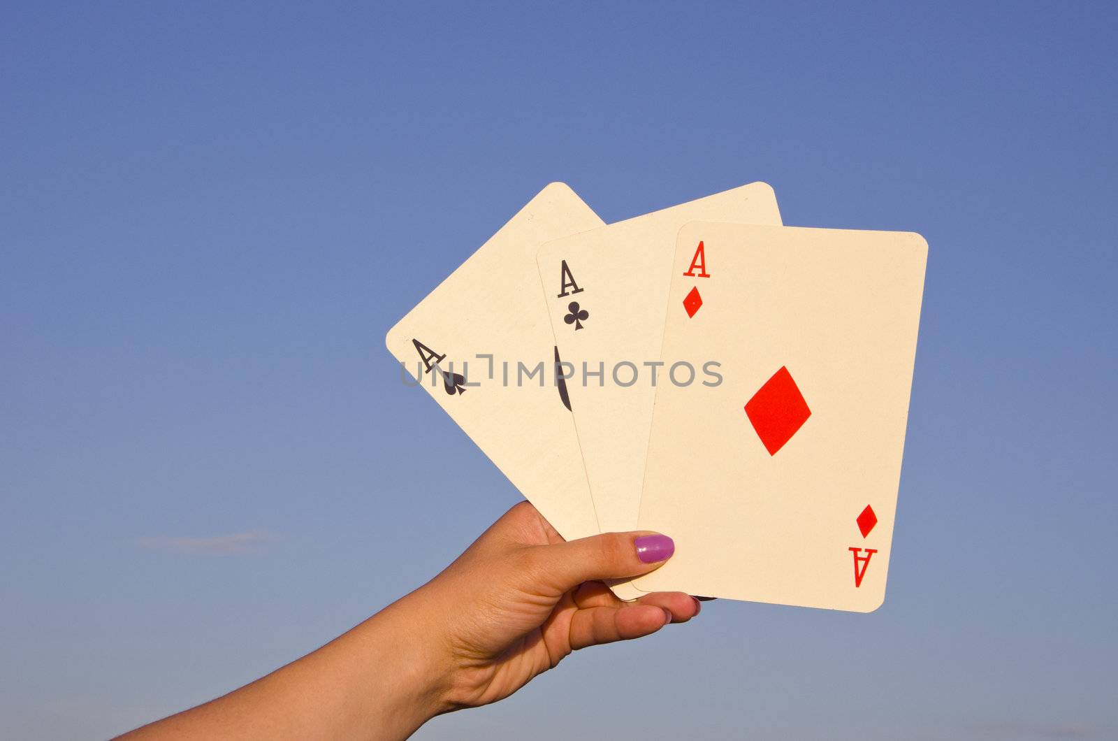 Hand holding good cards playing poker. Three of a kind. Aces.