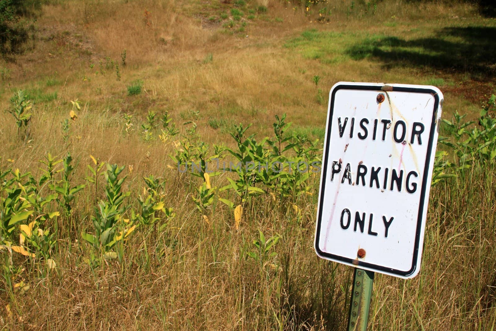 Parking sign for visitors in the middle of a field
