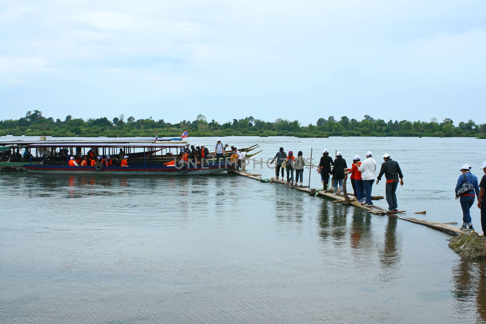 People going to boat on wooden pier