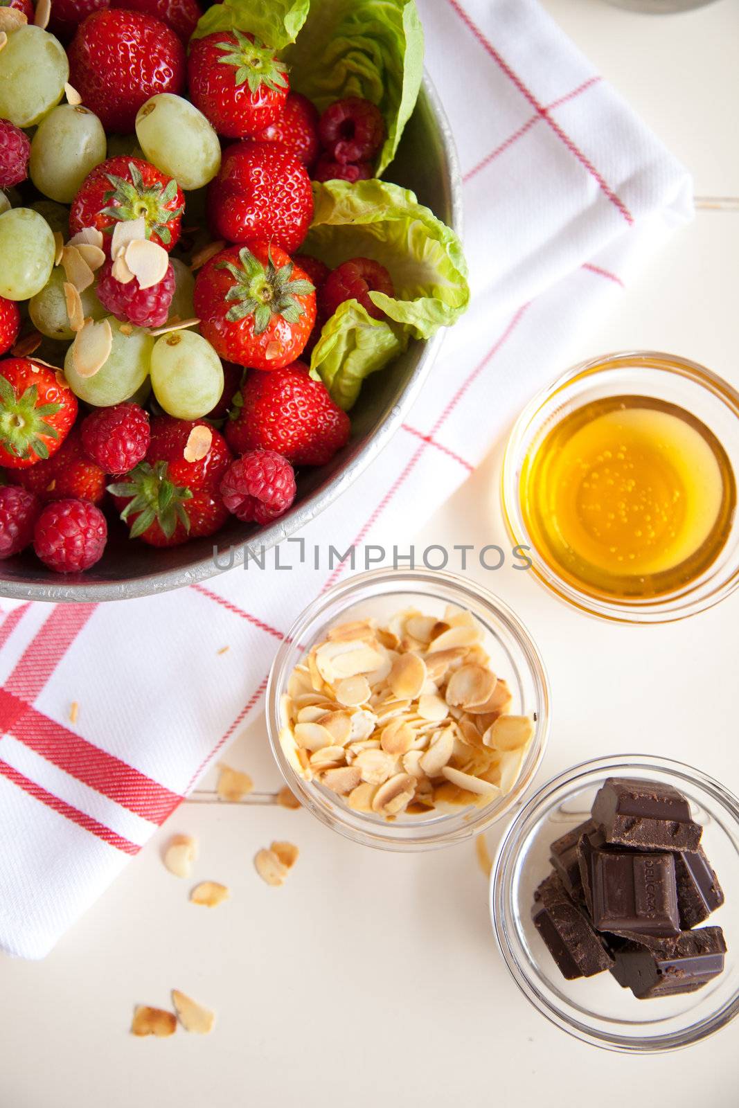 Big bowl with fruitsalad with grapes, strawberries and raspberries