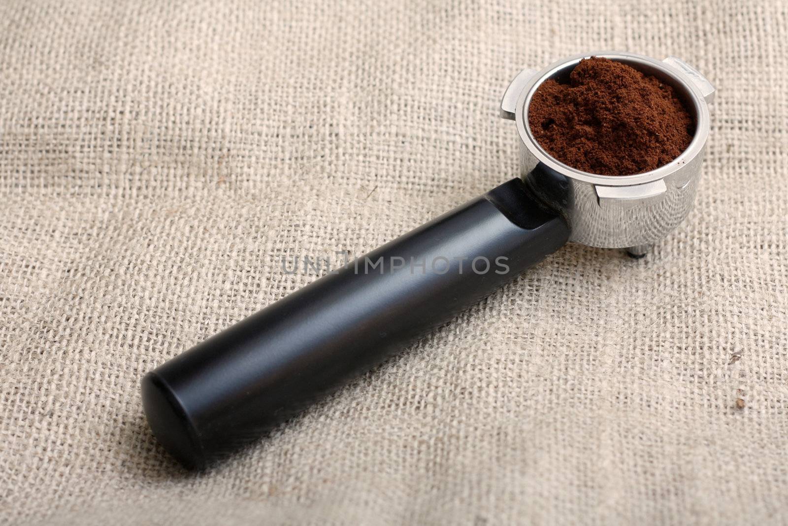 An espresso handle filled with ground coffee