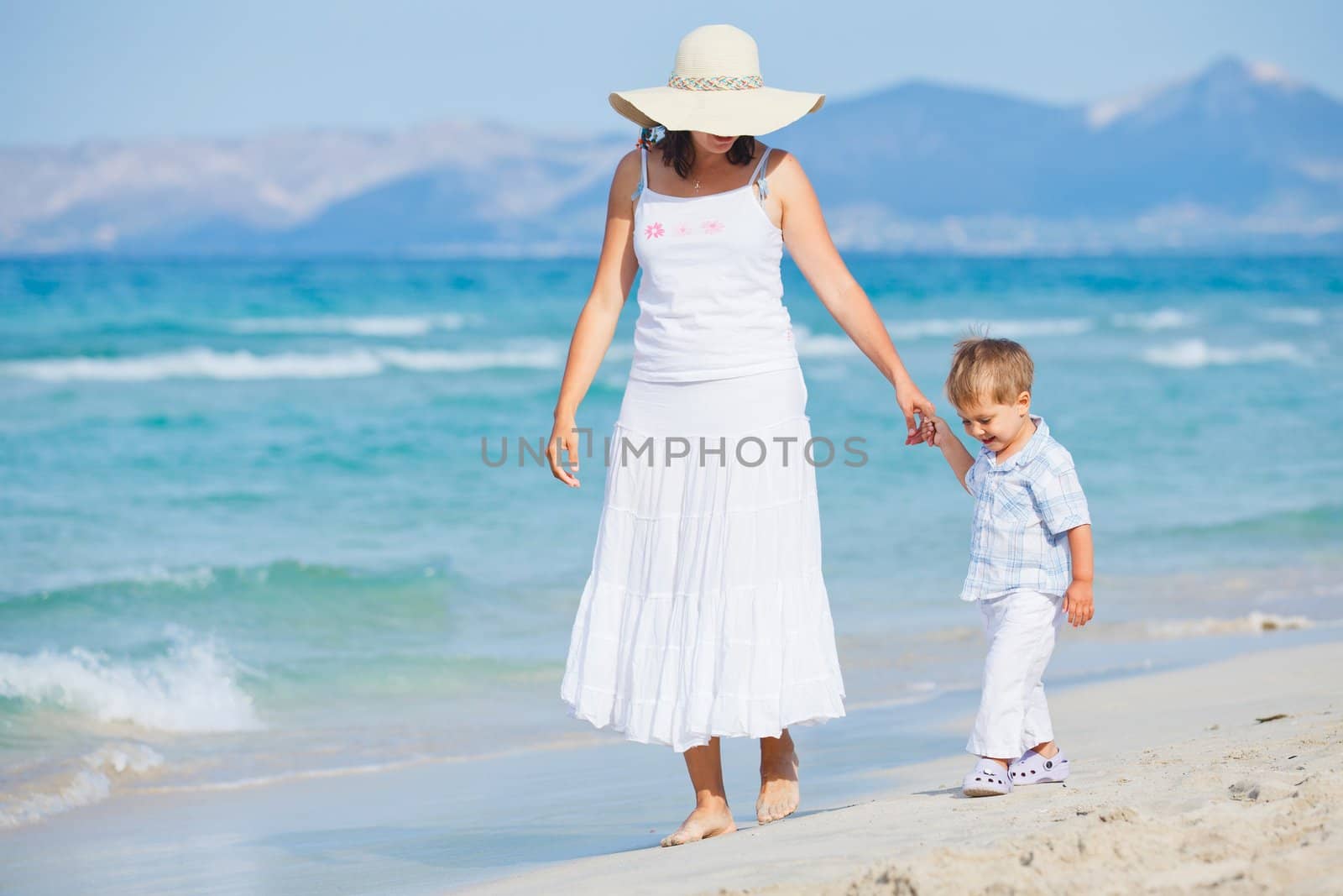 Young mother with her son on tropical beach vacation