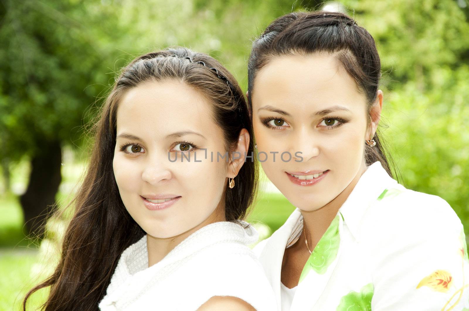 Portrait of two happy young women in a summer garden