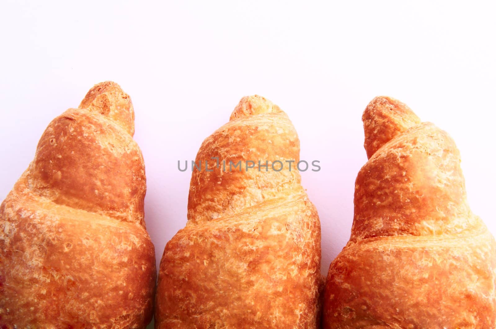 Background three fresh croissants, with a golden crust
