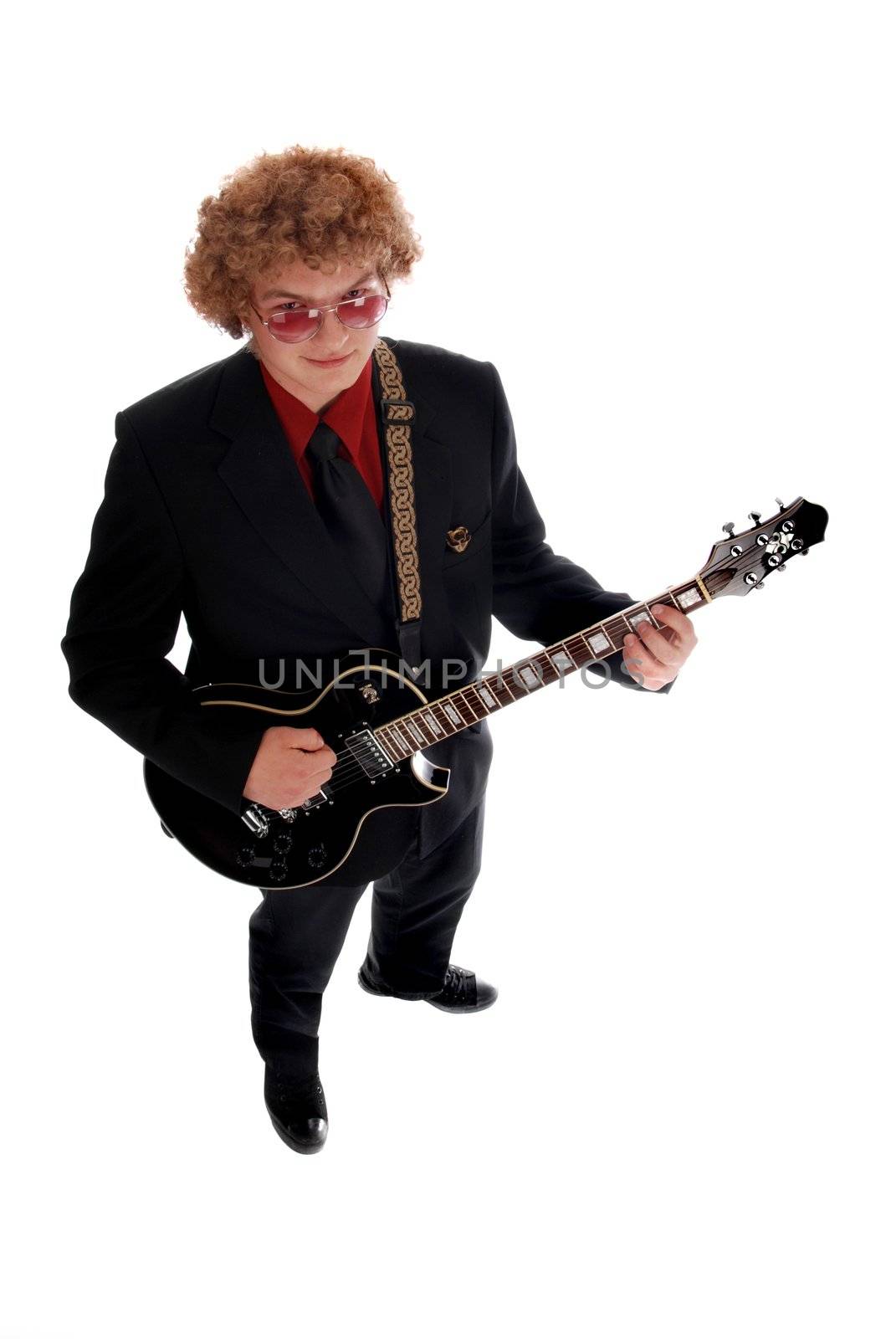 Young man in a black suite playing guitar