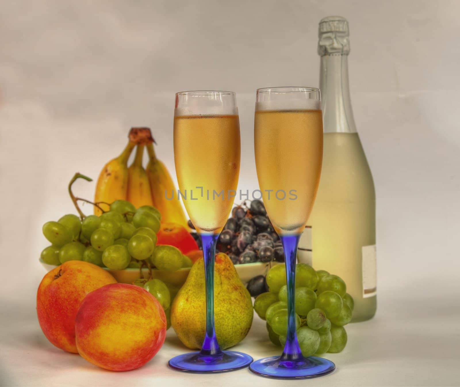 Champagne in glasses,bottle,apples,peach,pear,grapes and banana.
