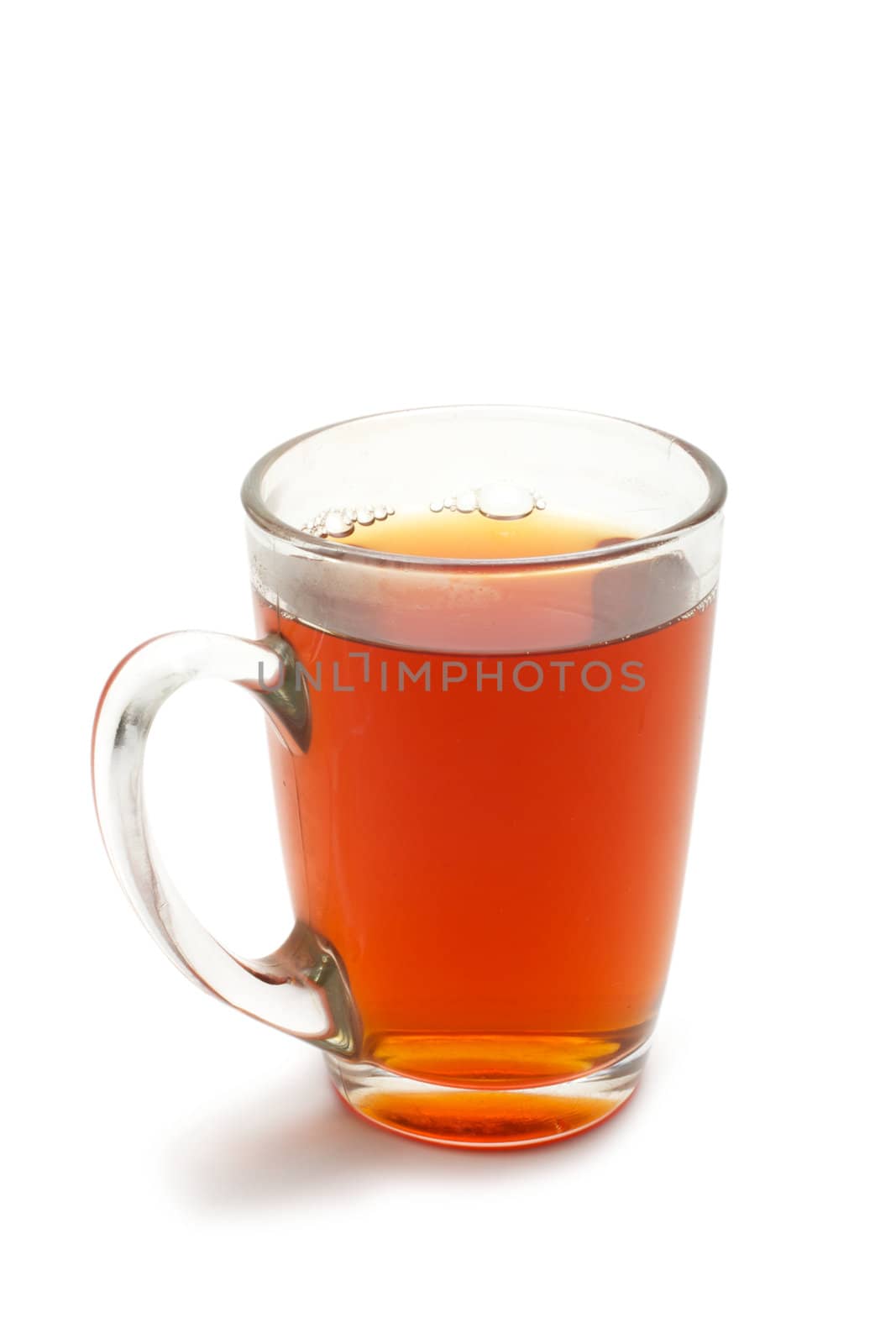 Glass cup with tea. The cup stands on a white background.