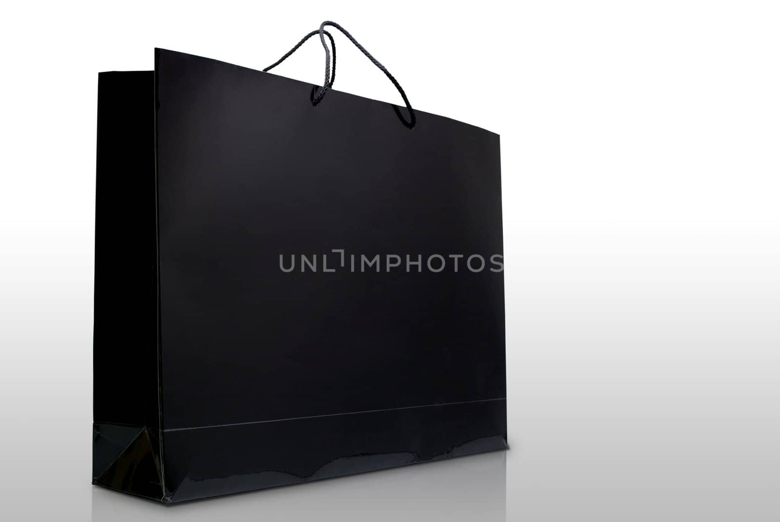 Black paper shopping bag on white background by pixbox77