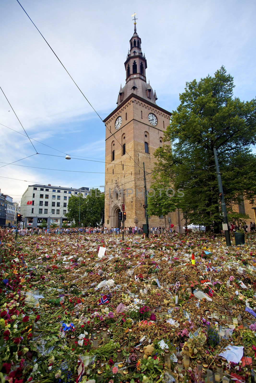OSLO NORWAY - JULY 31 2011: People lay down flowers, and lights candles outside the cathedral of Oslo to show respect for the victims of the bombing and shooting that took place July 22 2011, July 31, 2011, Oslo