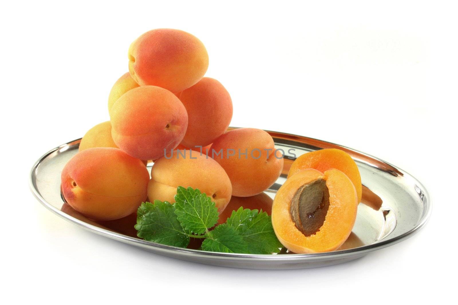 fresh apricots and lemon balm on white background