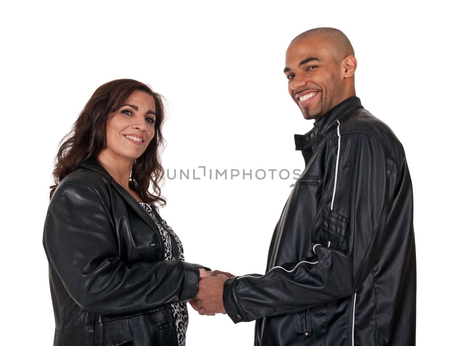 Multicultural couple holding hands and smiling. Mature woman with younger man.