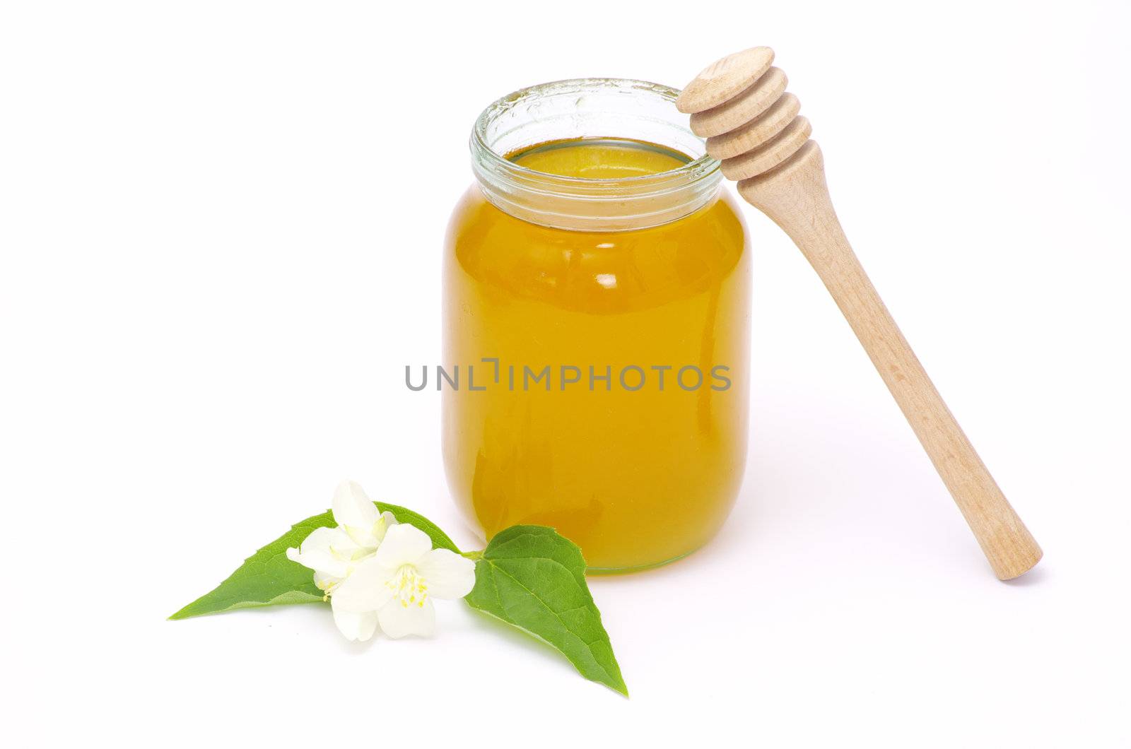 glass pot full of honey and stick isolated on white background