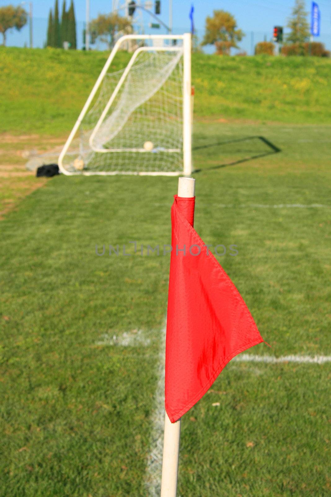 Red corner flag on a soccer field.
