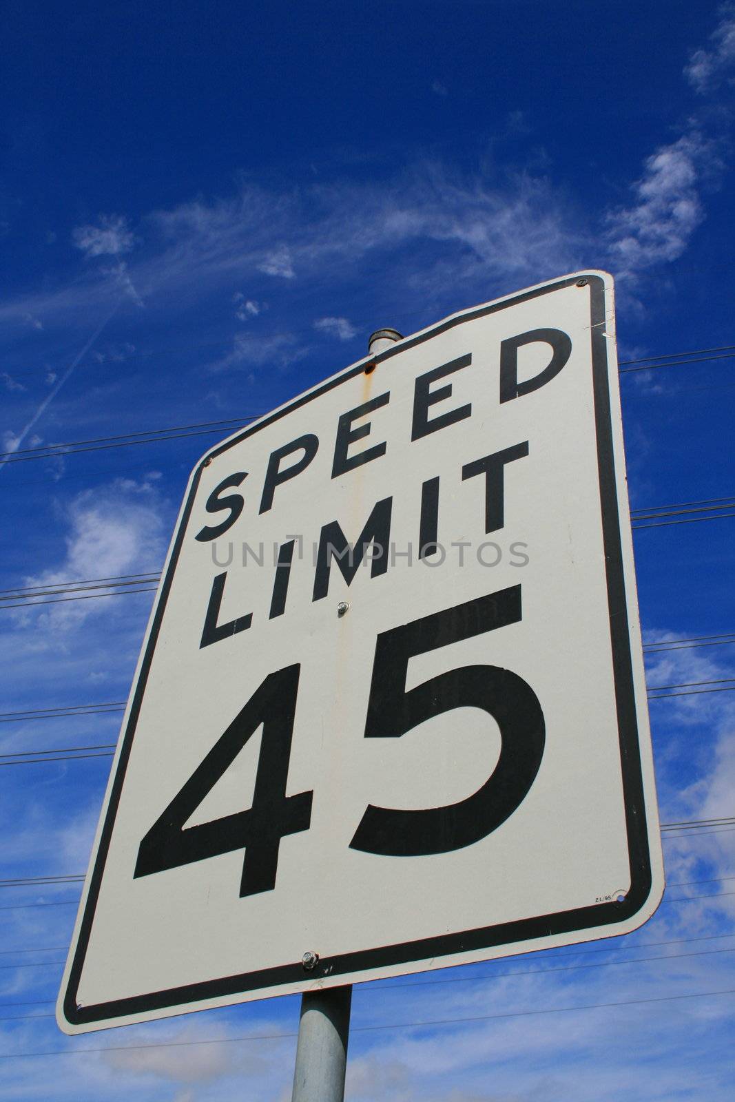 Speed limit road sign over blue sky.
