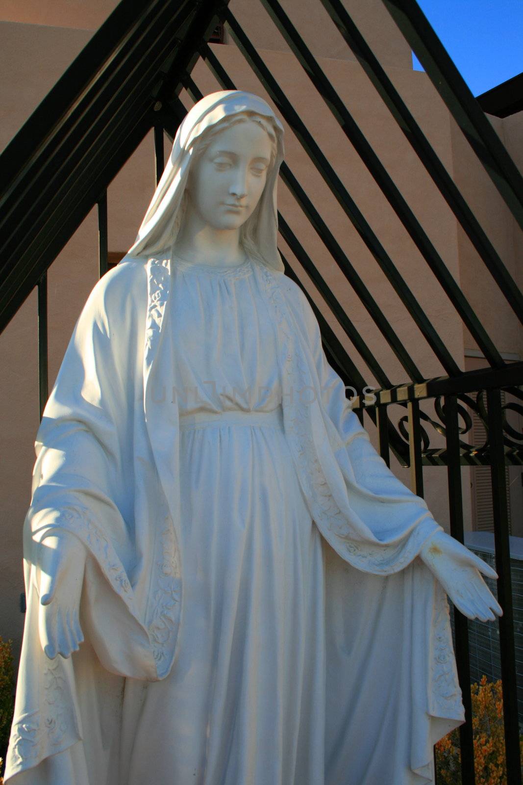 Statue of a Virgin Mary next to a church.
