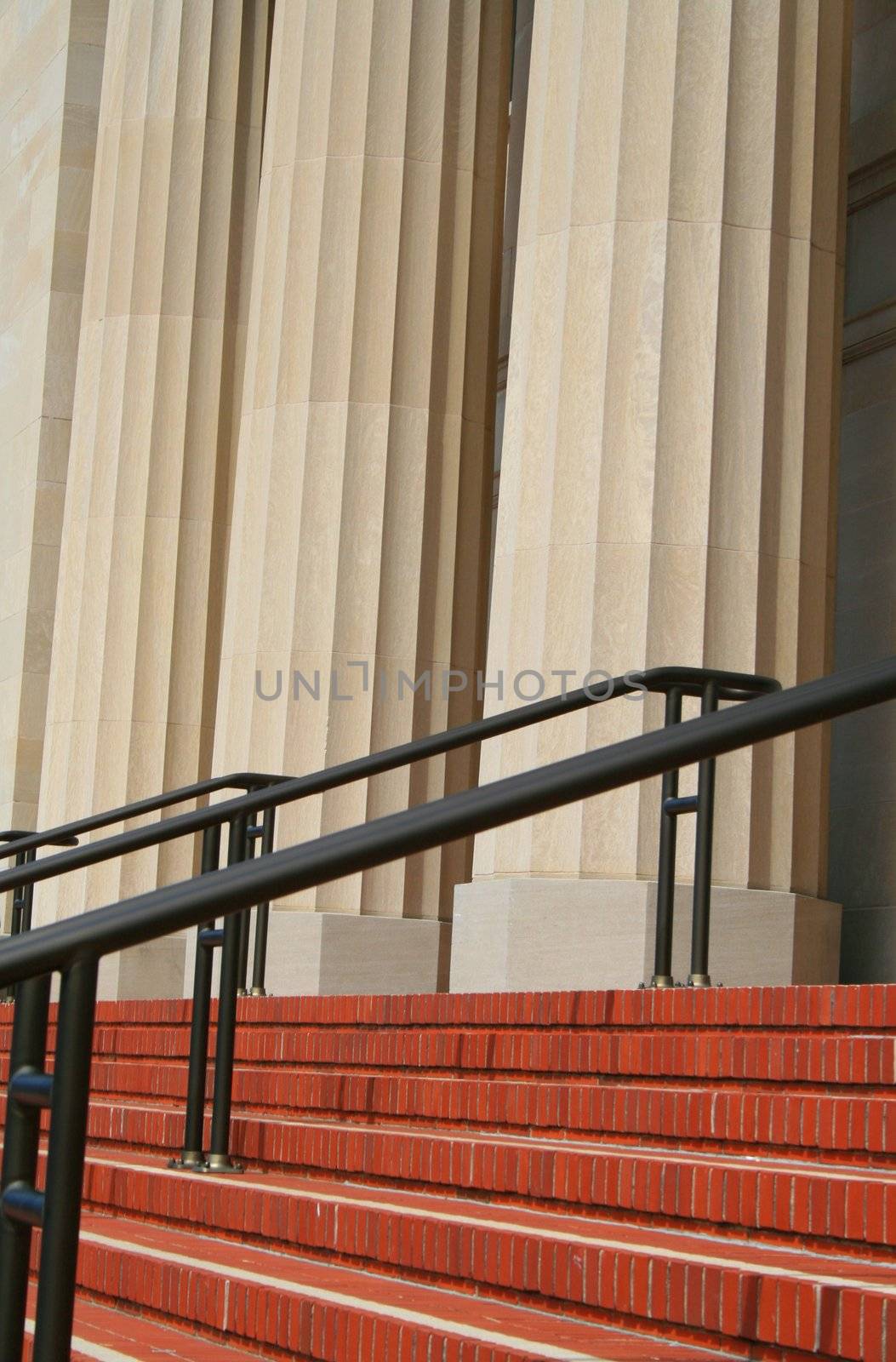 Steps and handrails next to a row of columns.
