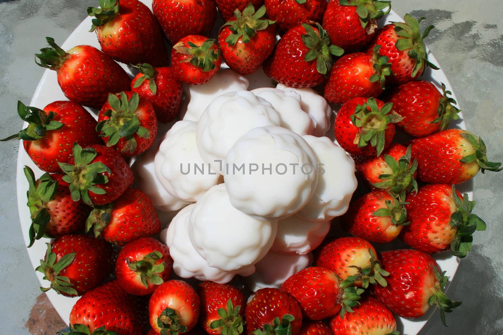 Close up of the strawberries on a plate with marshmellow cookies.
