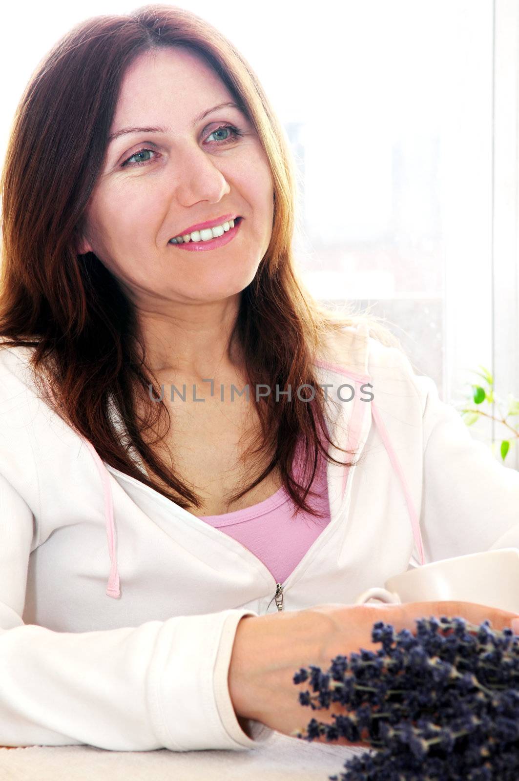 Smiling mature woman relaxing at home holding a cup