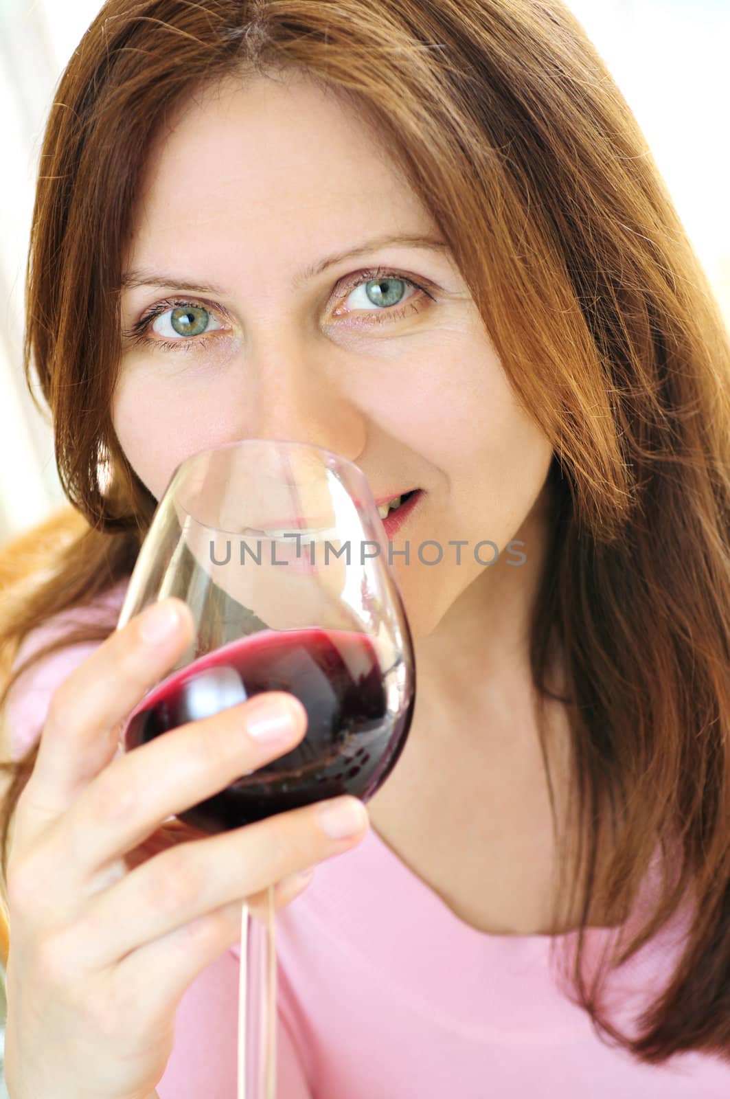 Mature woman with a glass of red wine by elenathewise