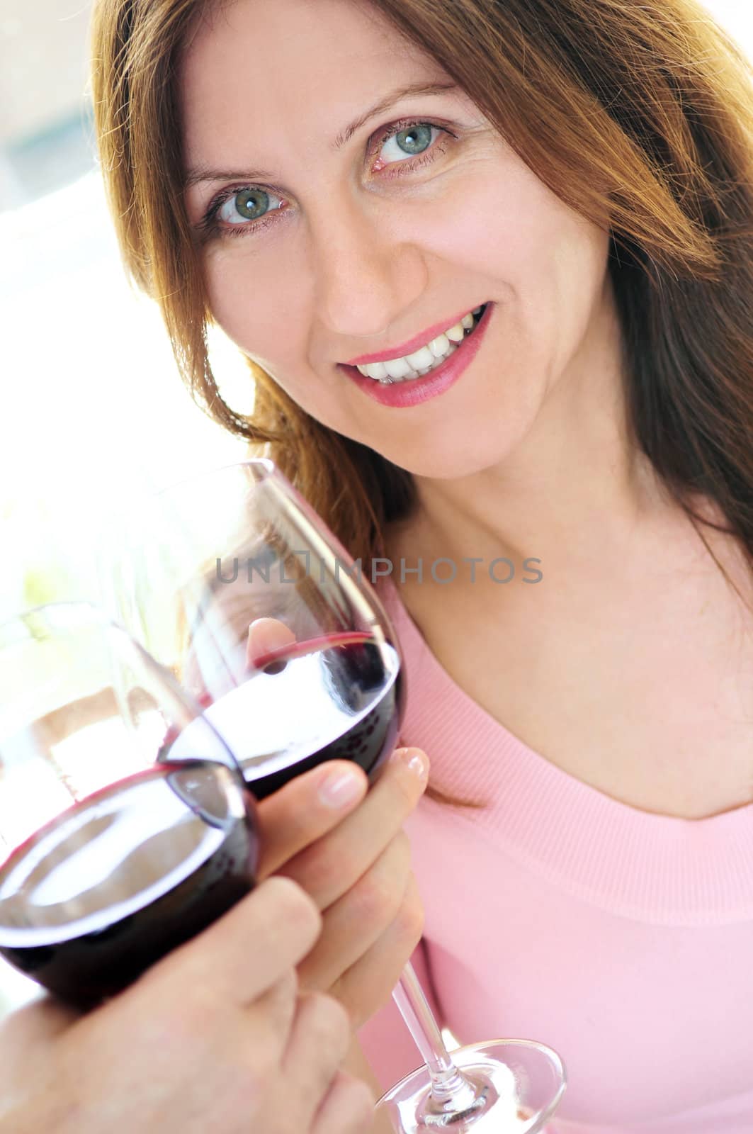 Mature woman toasting with a glass of red wine