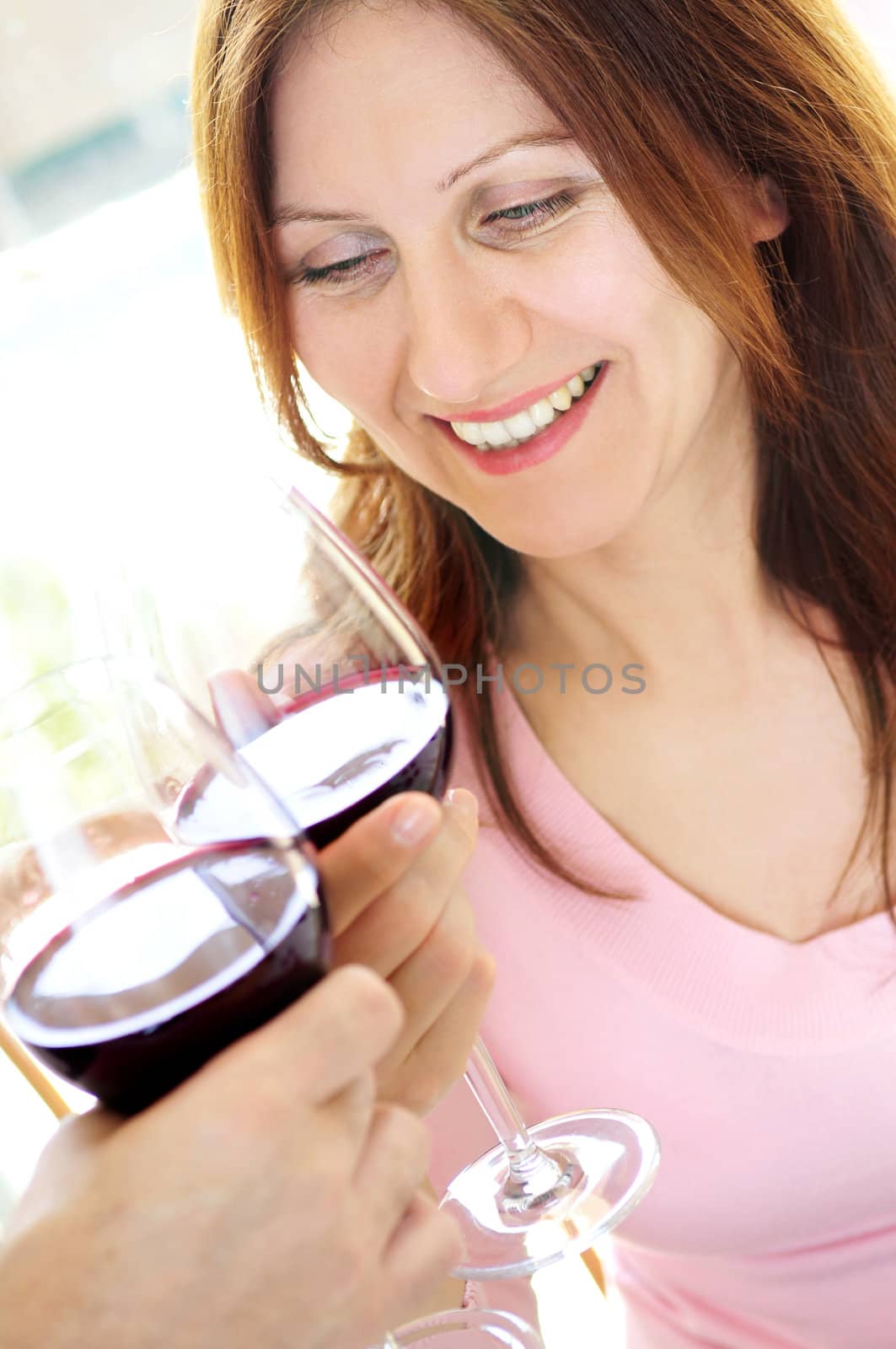 Mature woman toasting with red wine by elenathewise