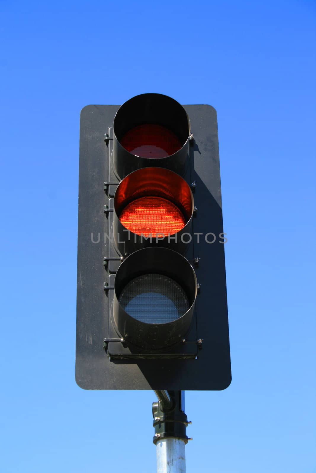 Close up of a traffic light showing amber light.
