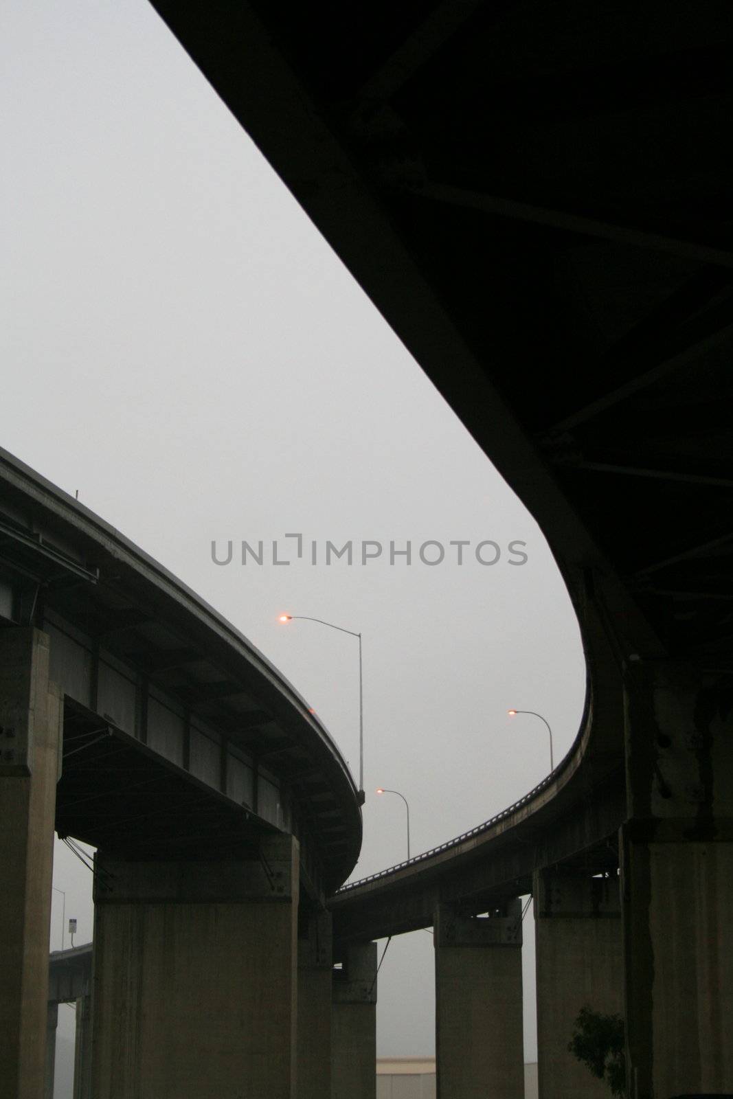 Close up of the empty freeway ramps in a fog.
