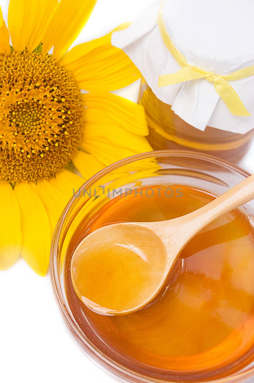 Honey in jar with wooden spoon and sunflower