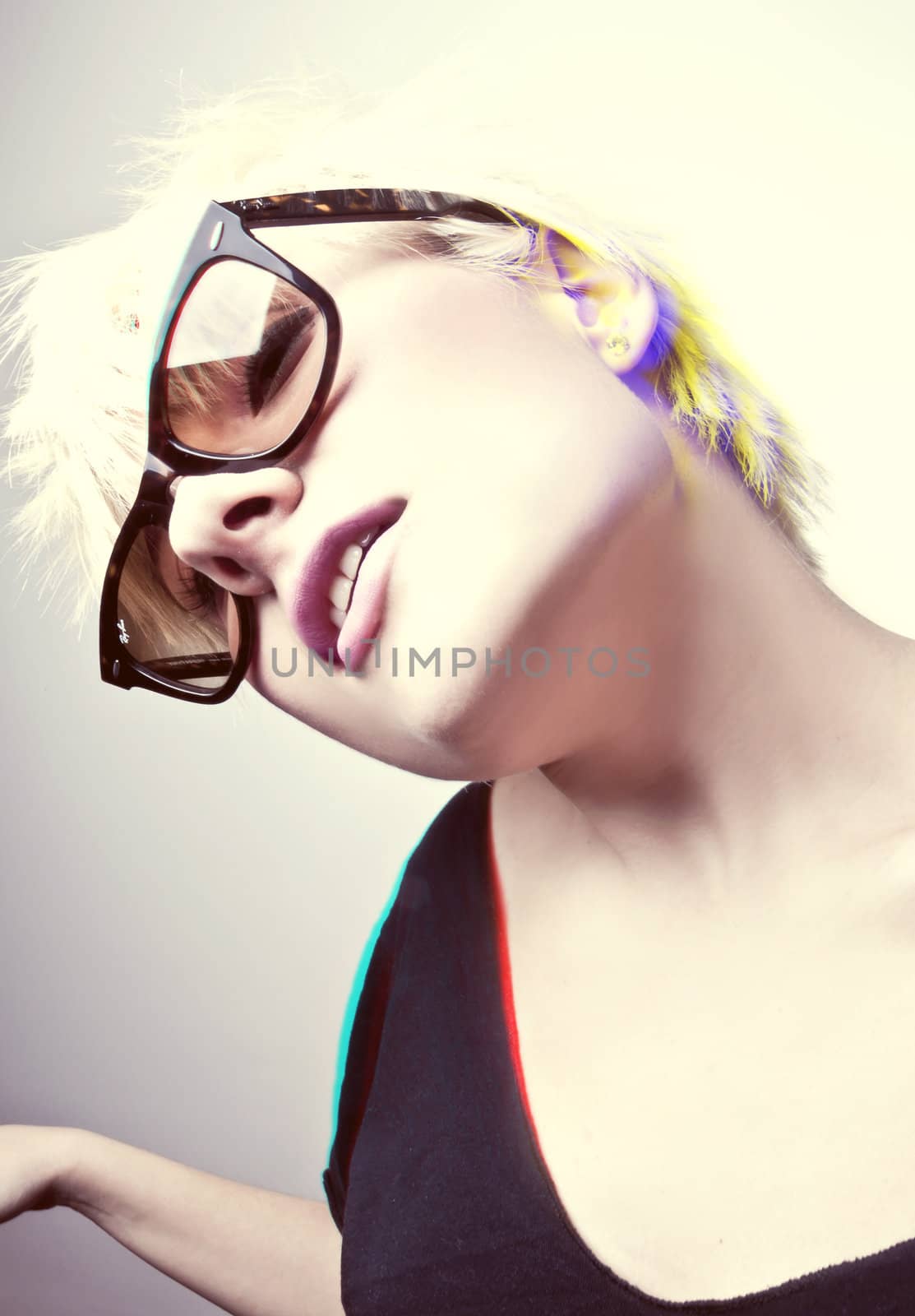 Portrait of a young, blonde girl with short hair and sunglasses