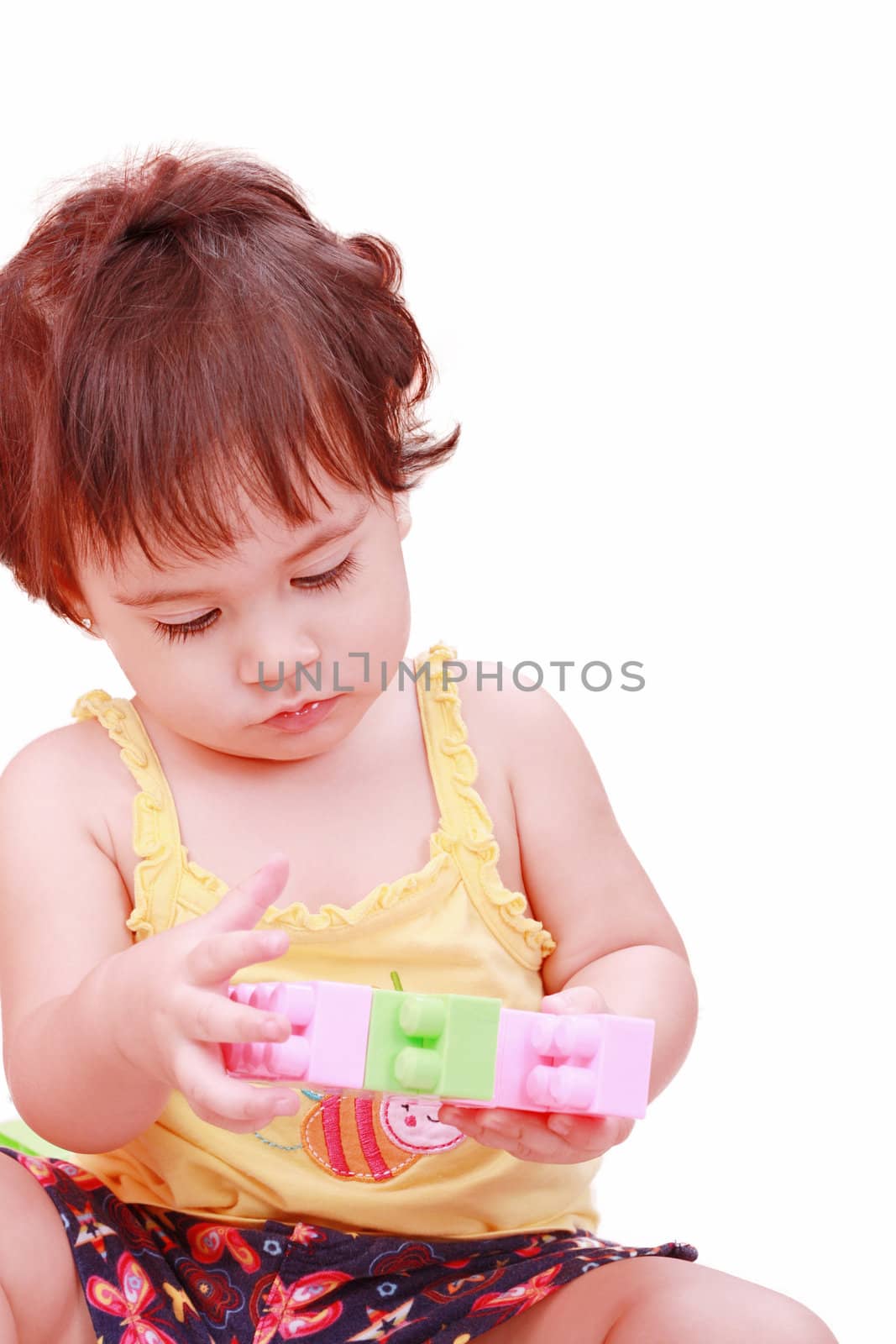Baby in yellow shirt playing with toys by dacasdo