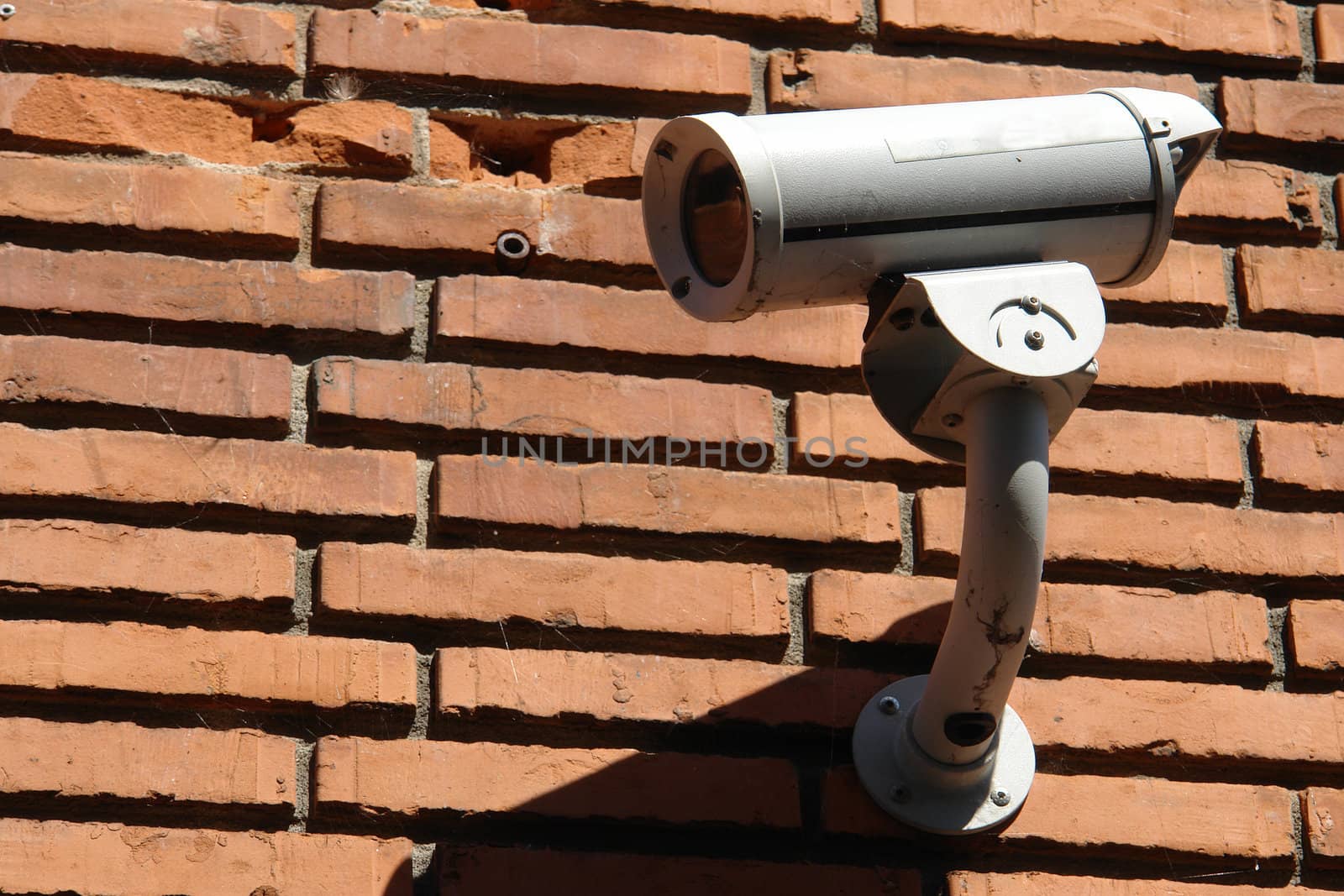 Security surveillance camera on a bricks wall Big Brother is watching                              