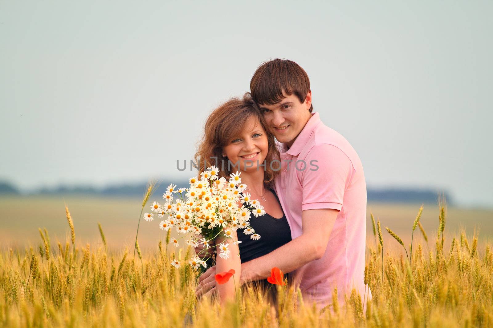 loving couple in a field of wheat by andrew_mayovskyy