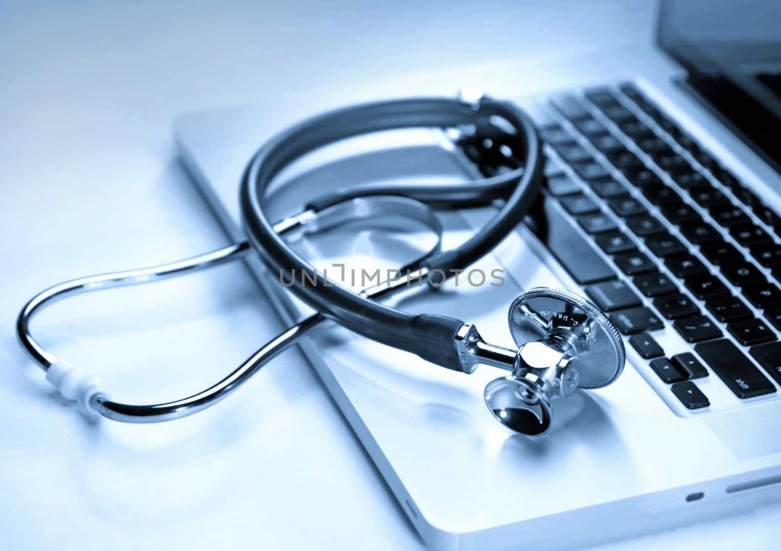 Medical stethoscope on a laptop computer in blues, closeup