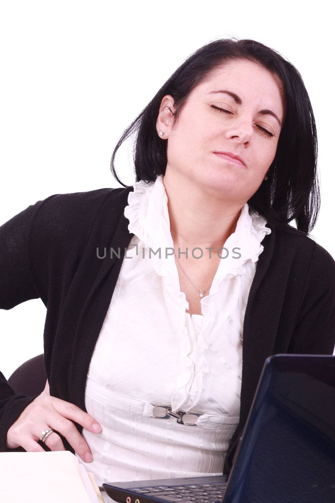 Young woman sitting at her laptop with a lot of work in front of by dacasdo
