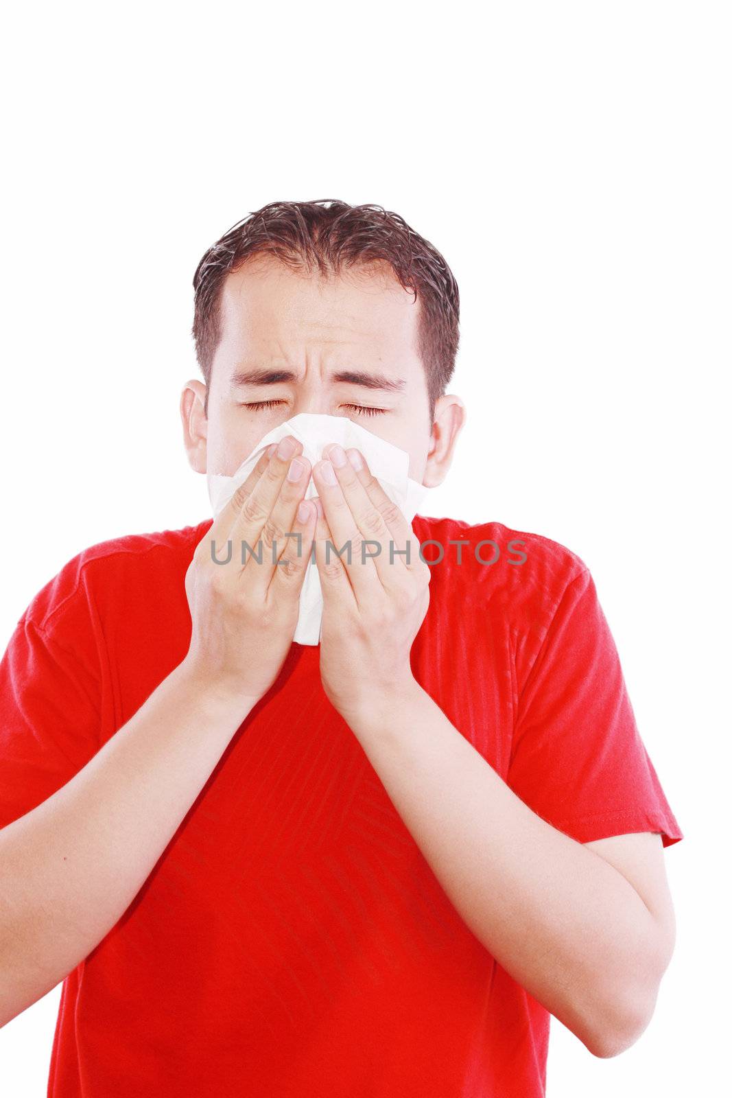 Young man with a cold blowing nose on tissue