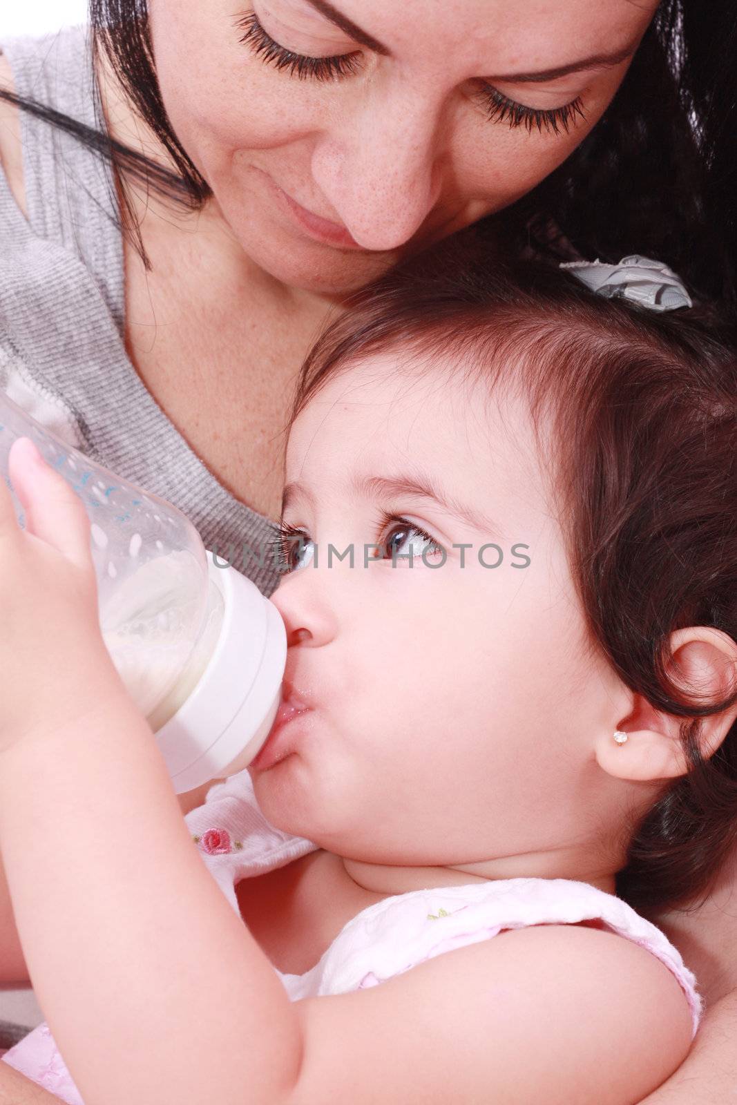 Mother and baby drinking milk from bottle in a white background by dacasdo